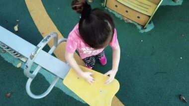 Bangi, Malezya - 7 Aralık 2021 Oyun parkında yağmurdan sonra suyla oynayan küçük kız. Gerçek zamanlı.