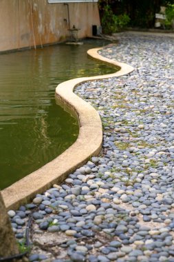 Refleksoloji çakıl yolunun yanındaki yeşil gölet.