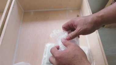 Bir adamın ellerini, baloncuk ambalajını kimyasal şişeyle açarak ve ticari nakliyeyle kapatıyoruz.,