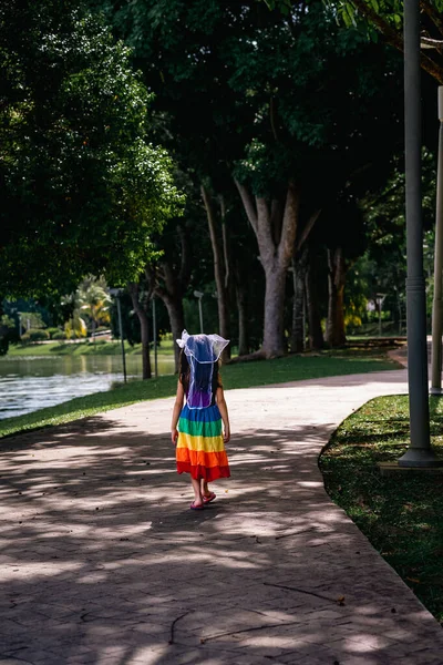 Een Klein Meisje Een Regenboog Jurk Leuk Hardlopen Het Betonnen — Stockfoto