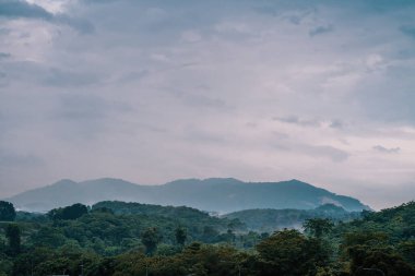 Tropical mountain range with visible silhouettes through the morning colorful fog.