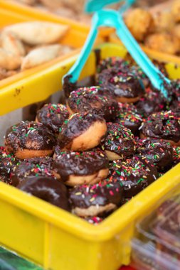 Çikolata kaplı çörek ve tezgahta satılık serpinti..