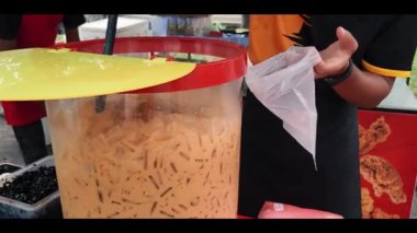 Nilai, Malaysia - April 24, 2022 Packing iced milk tea in the plastic container at the local market 