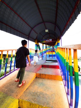 Rainbow bridge in Kuala Perlis. View of the colorful metal bridge extends across the fishing village. Selective focus.