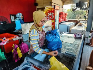 Setiu, Terengganu - 11 Mayıs 2022: Bayu Keropok Lekor çalışanları balık sosisli kraker satıyor.