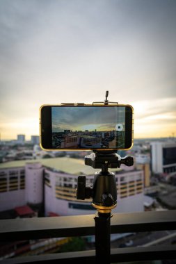 Dengeleyicili telefon, tripod, telsiz. Şehirde fotoğraf ve canlı video çekiyoruz. Vlog, video günlüğü, sokak fotoğrafçılığı kavramı.