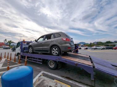 Perak, Malaysia - Aug 7, 2022 : Broken car on the truck with passenger to the workshop.