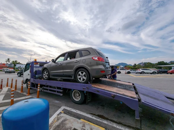 Perak, Malaysia - Aug 7, 2022 : Broken car on the truck with passenger to the workshop.