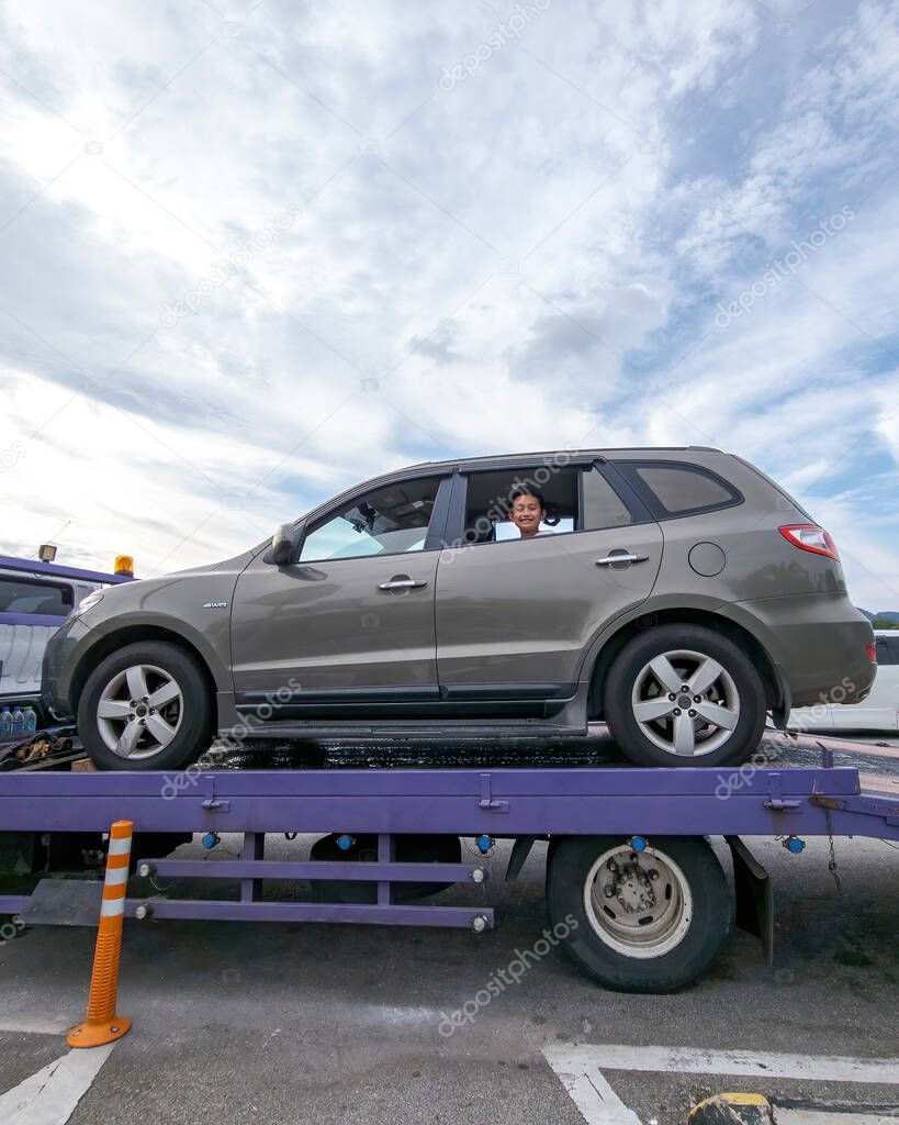 Perak, Malaysia - Aug 7, 2022 : Broken car on the truck with passenger to the workshop.