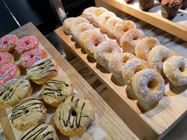 Pastanedeki lezzetli çörekler grubunu kapat, lezzetli çoklu donutlar, seçici bir şekilde donutlara odaklan.