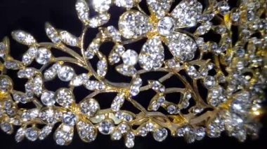 Işıl ışıl kadın aksesuarlarını yakın plan altın çerçeveli ve siyah arkaplanlı.