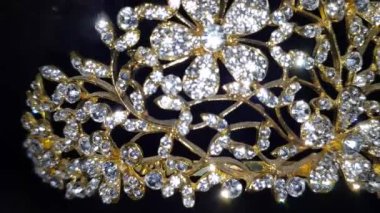 Işıl ışıl kadın aksesuarlarını yakın plan altın çerçeveli ve siyah arkaplanlı.