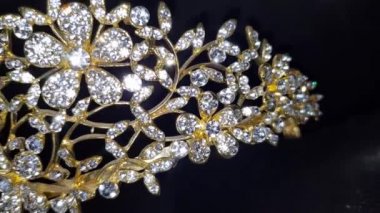 Işıl ışıl kadın aksesuarlarını yakın plan altın çerçeveli ve siyah arkaplanlı.