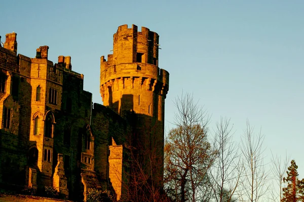 Ancient European medieval architectural building castle in golden autumn light with the blue sky background during autumn