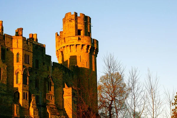 Ancient European medieval architectural building castle in golden autumn light with the blue sky background during autumn