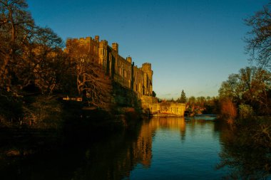 Antik Avrupa ortaçağ mimari şatosu Sonbaharda mavi gökyüzü arkaplanı ile altın sonbahar ışığı altında