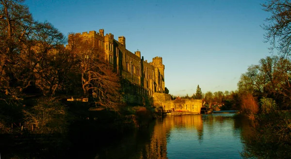 Ancient European medieval architectural building castle in golden autumn light with the blue sky background during autumn