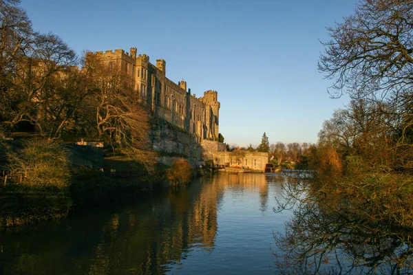 Ancient European medieval architectural building castle in golden autumn light with the blue sky background during autumn