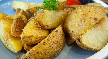 Baked potato wedges with shredded onion and herbs and tomato sauce platted homemade organic vegetable vegan vegetarian potato wedges snack food meal