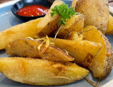 Baked potato wedges with shredded onion and herbs and tomato sauce platted homemade organic vegetable vegan vegetarian potato wedges snack food meal