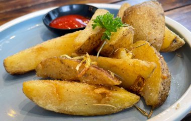Baked potato wedges with shredded onion and herbs and tomato sauce platted homemade organic vegetable vegan vegetarian potato wedges snack food meal