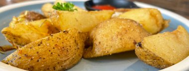 Baked potato wedges with shredded onion and herbs and tomato sauce platted homemade organic vegetable vegan vegetarian potato wedges snack food meal