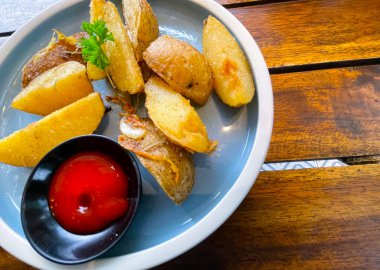Top View Baked potato wedges with shredded onion and herbs and tomato sauce platted homemade organic vegetable vegan vegetarian potato wedges snack food meal