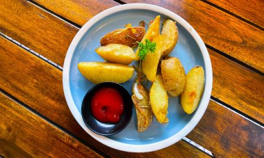 Top View Baked potato wedges with shredded onion and herbs and tomato sauce platted homemade organic vegetable vegan vegetarian potato wedges snack food meal