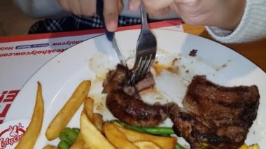 Dünyanın en iyi yemeklerini yemenin sevinci yanında patates püresi, mantar sosu ve tatlı mısırla birlikte beyaz tabakta servis edilen yeşil fasulye.