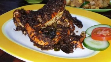 Delicious Indonesian seafood crab dish cooked with spices and seasoning sauce wrapped in banana leaf plate with other background dishes in Indonesian restaurant stock video