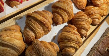 Close up group of fresh baked delicious croissants, super delicious warm fresh buttery Croissants and Rolls, French and American Croissants and baked pastries are enjoyed world wide on bakery shop, tasty multiple croissant