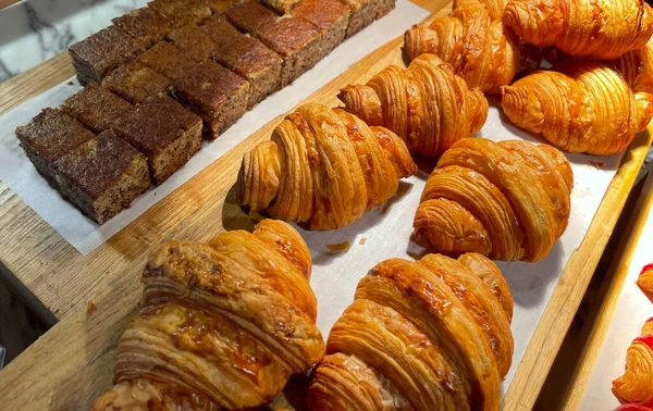 Close up group of fresh baked delicious croissants, super delicious warm fresh buttery Croissants and Rolls, French and American Croissants and baked pastries are enjoyed world wide on bakery shop, tasty multiple croissant