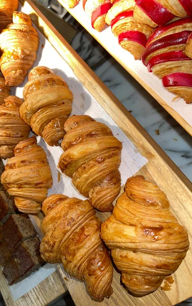 Close up group of fresh baked delicious croissants, super delicious warm fresh buttery Croissants and Rolls, French and American Croissants and baked pastries are enjoyed world wide on bakery shop, tasty multiple croissant