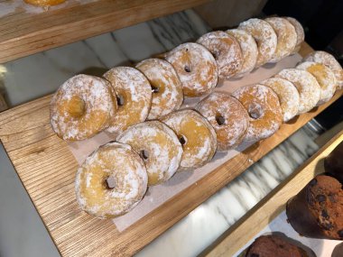 Lines of fresh delicious donuts on bakery shop, tasty multiple donuts, Selective focus donuts with various topping