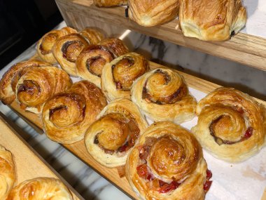 Lines of fresh baked cinamon rolls, super delicious cinamon rolls, French and American Croissants and baked cinamon rolls are enjoyed world wide on bakery shop, tasty multiple baked cinamon rolls