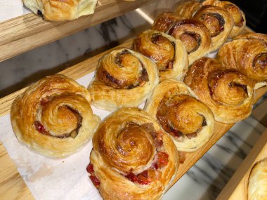 Lines of fresh baked cinamon rolls, super delicious cinamon rolls, French and American Croissants and baked cinamon rolls are enjoyed world wide on bakery shop, tasty multiple baked cinamon rolls