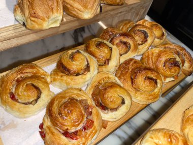 Lines of fresh baked cinamon rolls, super delicious cinamon rolls, French and American Croissants and baked cinamon rolls are enjoyed world wide on bakery shop, tasty multiple baked cinamon rolls