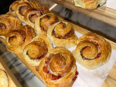 Lines of fresh baked cinamon rolls, super delicious cinamon rolls, French and American Croissants and baked cinamon rolls are enjoyed world wide on bakery shop, tasty multiple baked cinamon rolls