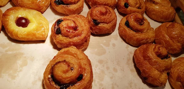 フルーツとゼリーが詰められた焼きたての甘いパフペーストリーとデニッシュチョコレートのフィリングペストリー 超おいしい暖かい新鮮なバターフランスとアメリカの焼き菓子はパン屋さんで世界中で楽しんでいます おいしい複数の甘いパフペーストリーの詰め物 — ストック写真