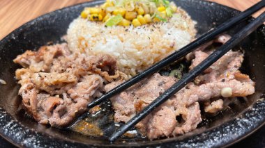 Kore soslu ızgara biftek ve yanında pirinç, biber ve mısır dilimleri. Kore usulü ve Japon usulü bir restoranda.