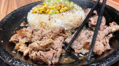 Kore soslu ızgara biftek ve yanında pirinç, biber ve mısır dilimleri. Kore usulü ve Japon usulü bir restoranda.