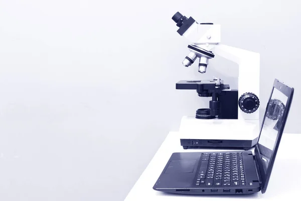 研究室のテーブルの上の顕微鏡とノートパソコン — ストック写真