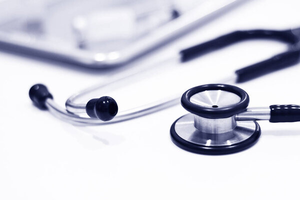 Stethoscope with out of focus of Vial of Drug, Plastic Syringe with Needle and stainless steel tray Isolated on the White Background