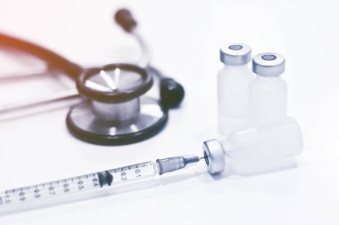 Uyuşturucu şişesi, 1 ml plastik şırınga, iğneli ve odaksız steteskop, beyaz arka planda izole edilmiş.