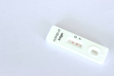 Beyaz arka planda Covid-19 antijen test kitinin pozitif test sonuçları