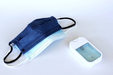 Covid-19 kavramının önlenmesi: Beyaz arkaplanda maske ve alkol spreyi