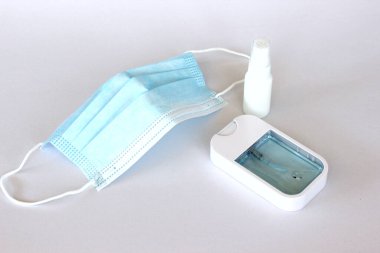 Covid-19 kavramının önlenmesi: Beyaz arkaplanda maske ve alkol spreyi