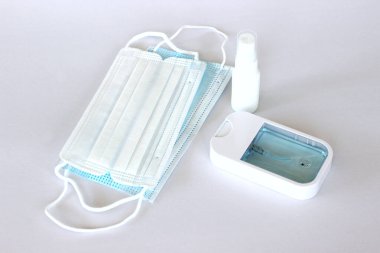 Covid-19 kavramının önlenmesi: Beyaz arkaplanda maske ve alkol spreyi