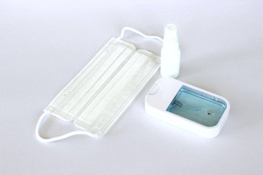 Covid-19 kavramının önlenmesi: Beyaz arkaplanda maske ve alkol spreyi