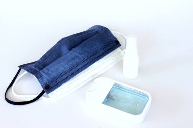 Covid-19 kavramının önlenmesi: Beyaz arkaplanda maske ve alkol spreyi